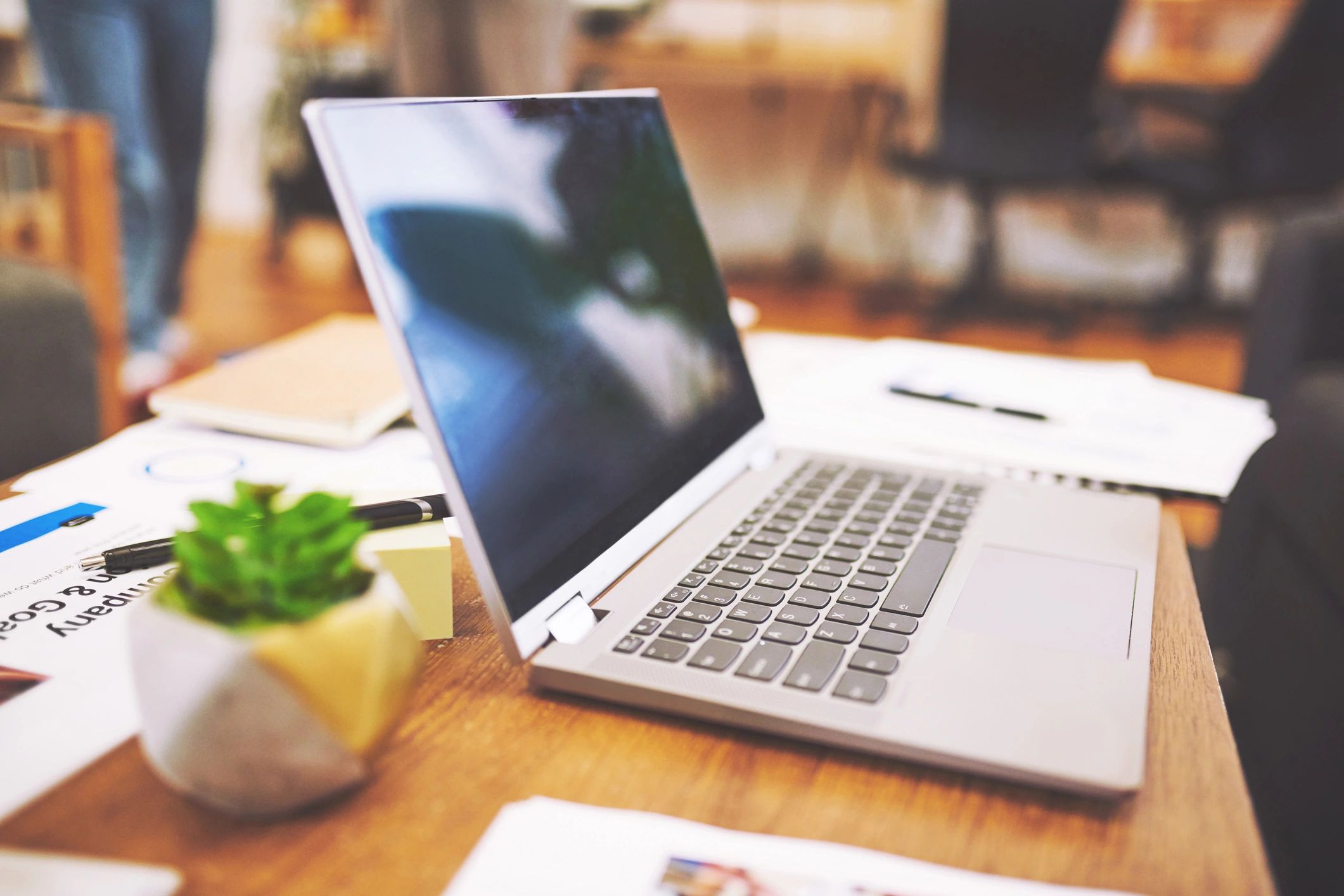 Laptop and paperwork on a desk representing technical documentation work